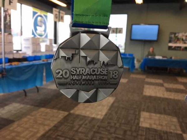 Medal that Reads Syracuse Half Marathon 2018
