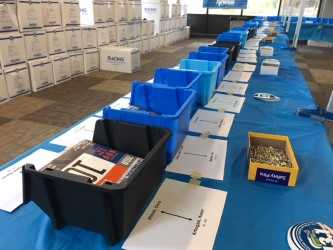 Table lined with bins and paper with packets for registration.
