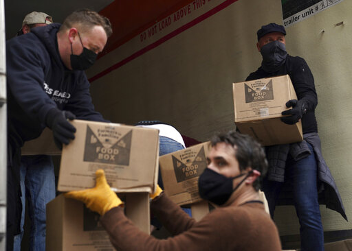 Volunteers unload boxes of food from a truck for a distribution program run through Mosaic West Queens Church in the Sunnyside neighborhood of the Queens borough of New York on Monday, Feb. 22, 2021. The program gives out more than 1,000 boxes of food to families twice a week.