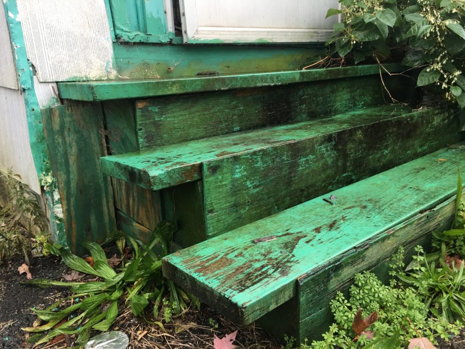 Porch steps with peeling paint close to ground