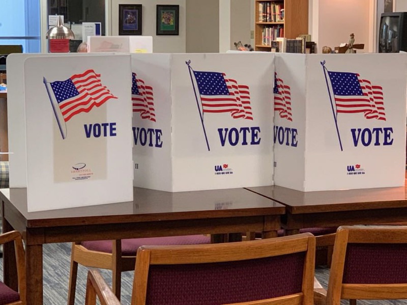 White voting booths on brown table.