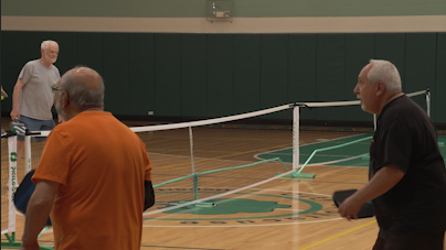 Norm Caffrey plays pickleball against his opponent.