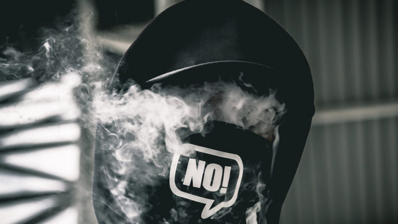 A person vaping with a mask on that says no