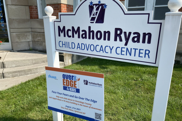 McMahon Ryan Child Advocacy Center sign along with Over the Edge 4 Kids fundraiser yard sign.