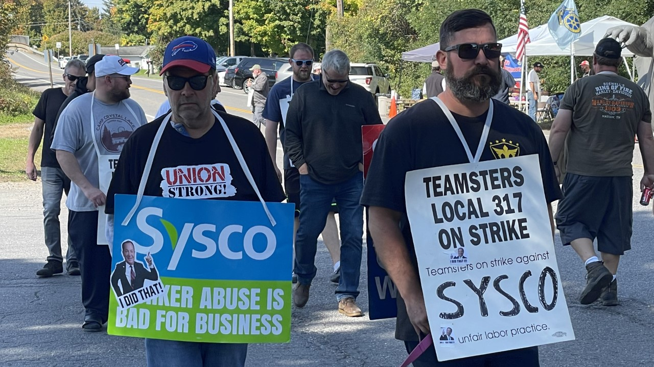 Sysco employees walking on strike with signs on them