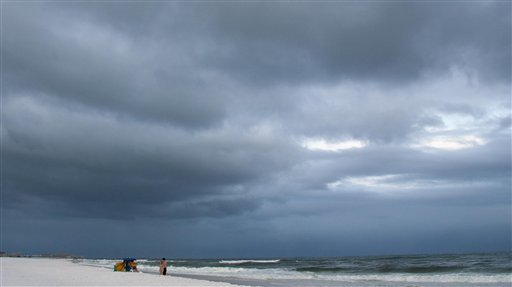 Beach goers stand beach side as dark clouds form in Fort Walton Beach, Fla., Sunday, Aug. 16, 2009, ahead Tropical Storm Claudette. (AP Photo/Mari Darr~Welch)