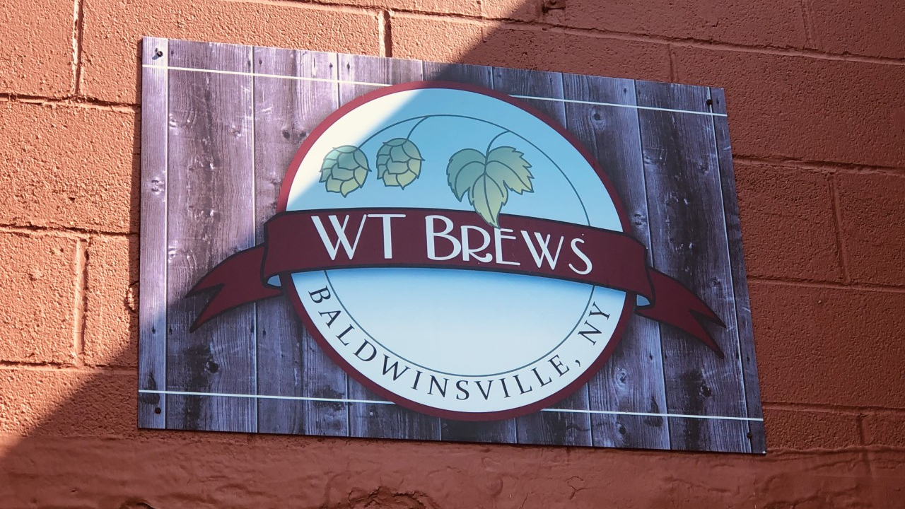 The WT Brews logo sits above the front doors of their Baldwinsville location.